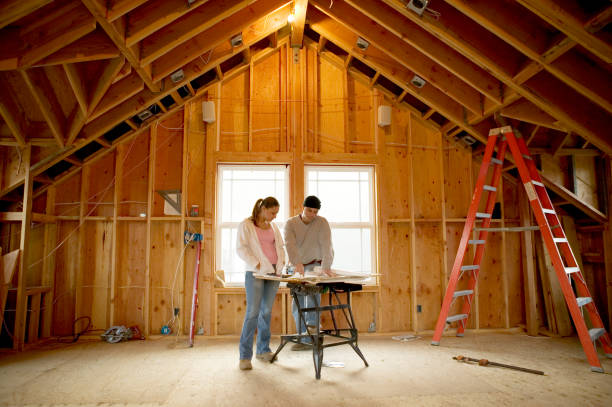 man and young woman looking at blueprints in house under construction - home decoration stock pictures, royalty-free photos & images