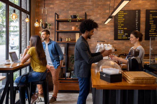 man at a cafe buying coffees to go - junk food stock pictures, royalty-free photos & images