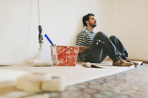 man during a break while painting apartment. - home decoration stock pictures, royalty-free photos & images