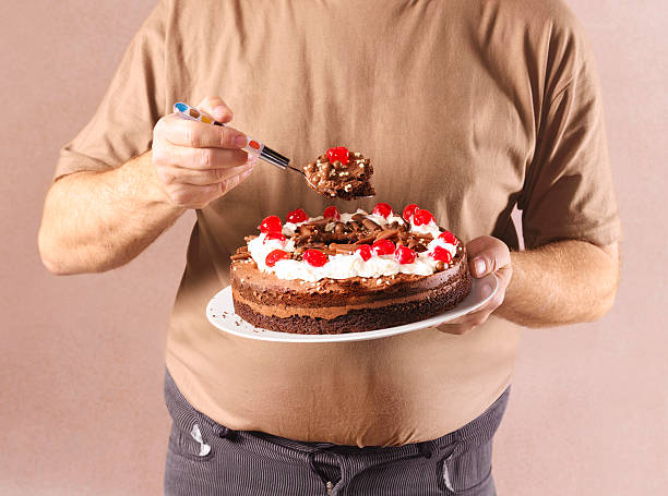 man eating chocolate cake, close-up - junk food stockfoto's en -beelden