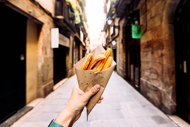 man eating churros on the streets of barcelona, personal perspective view, spain - junk food stock pictures, royalty-free photos & images