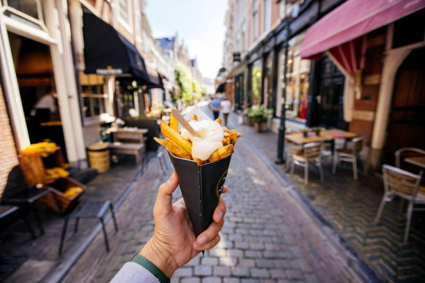 man eating french fries on the street, personal perspective - food stock pictures, royalty-free photos & images