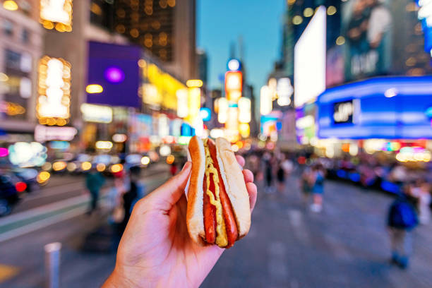 man eating hot dog at times square, personal perspective view, new york, usa - food stock pictures, royalty-free photos & images