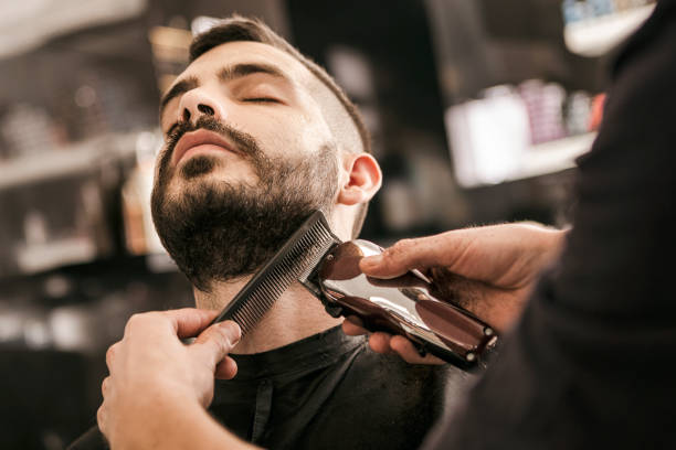 man krijgt van zijn baard gegarneerd met elektrisch scheerapparaat - hairstyle stockfoto's en -beelden