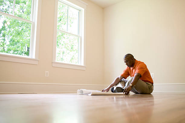 man looking at blueprints in empty room - home decoration stock pictures, royalty-free photos & images