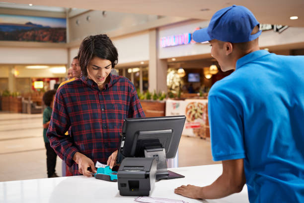 man paying for movie tickets at lobby - junk food stock pictures, royalty-free photos & images