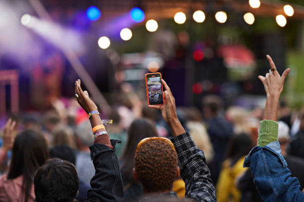 man photographing through mobile phone with friends - concert stock pictures, royalty-free photos & images