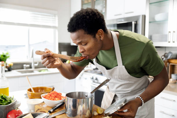 man preparing dinner in kitchen - food stock pictures, royalty-free photos & images
