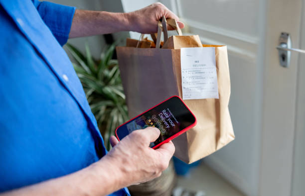 man rating his experience on the app after ordering food to his house - food stock pictures, royalty-free photos & images