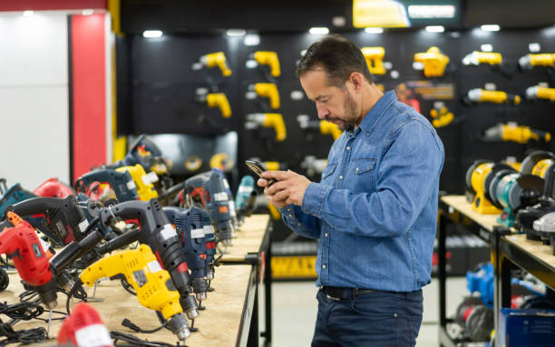 man shopping at a hardware store and taking a photo of the tools - home decoration stock pictures, royalty-free photos & images