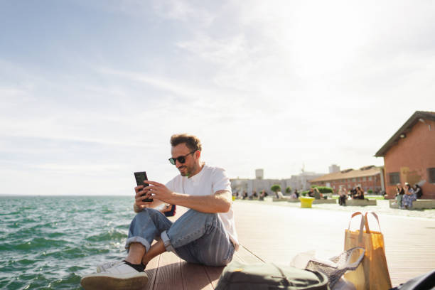 man sitting on the pier - travel stock pictures, royalty-free photos & images