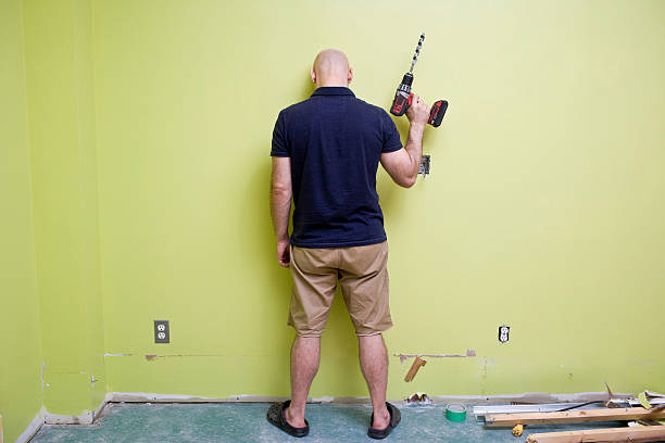 man stands looking frustrated with home renovations - home decoration stock pictures, royalty-free photos & images