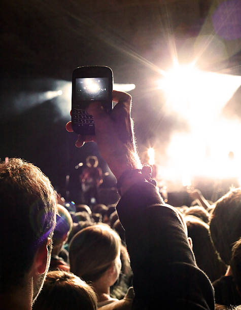 man taking picture at concert - concert stock pictures, royalty-free photos & images