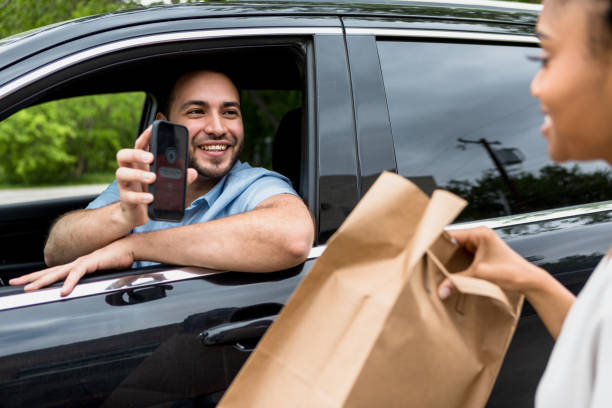 man uses mobile app to pick up food order - junk food stock pictures, royalty-free photos & images