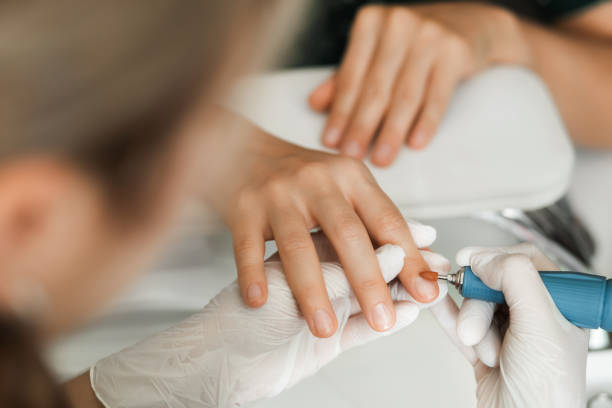manicurist doing hardware manicure to female client using special tools. - nails art stock pictures, royalty-free photos & images