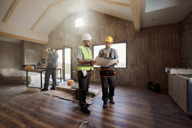 manual workers examining housing plan at construction site. - home decoration stock pictures, royalty-free photos & images