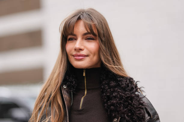 Mara LaFontan wears, deep dark brown half zipped turtleneck long sleeve sweater, shiny dark brown dark brown faux fur leather Michael Kors jacket,...