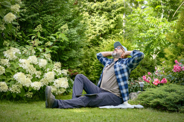 mature adult man gardener working in the garden - garden decoration stock pictures, royalty-free photos & images