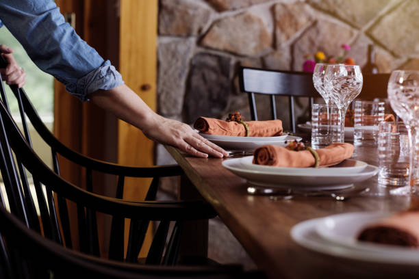 mature woman arranging dinner table at home - home decoration stock pictures, royalty-free photos & images