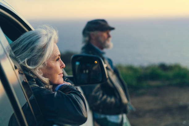 mature woman sitting in car during sunset - travel stock pictures, royalty-free photos & images