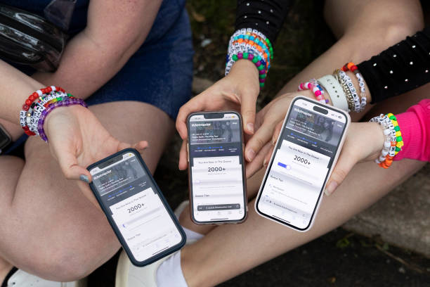 May 13: Anna Mason, Emily Lind, and Kristen Robinson show their Ticketmaster queue, which displays over 2000+ people ahead of them, from the parking...