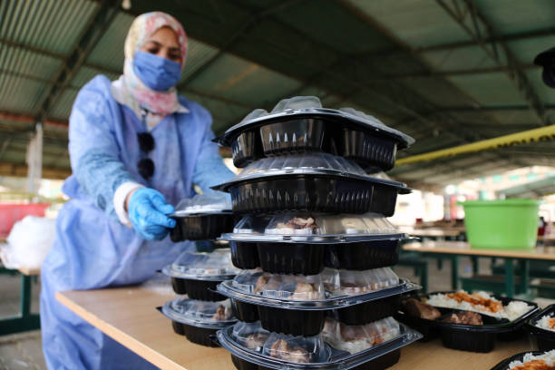 May 15, 2020 -- A woman prepares free takeaway meals in Cairo, Egypt, on May 15, 2020. "Your free meal is ready. Take it and eat at home," reads a...