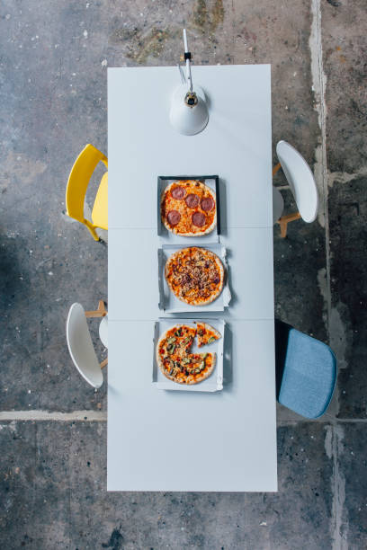 meeting table with pizza - junk food stock pictures, royalty-free photos & images