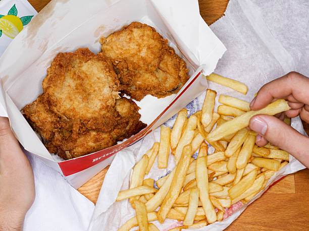 men eating fast food, fries chicken and fries - junk food stock pictures, royalty-free photos & images