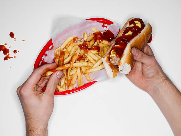 messy eating, hot dog and fries, overhead view - junk food stock pictures, royalty-free photos & images