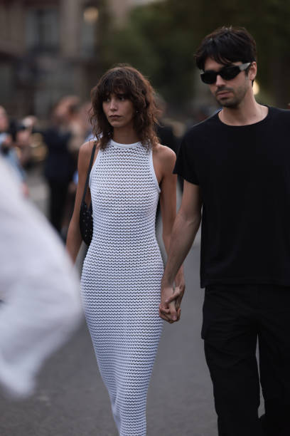 Mica Arganaraz is seen wearing Alaia white net dress, Alaia black leather sandals and a black shoulder bag outside Alaia show during the Haute...