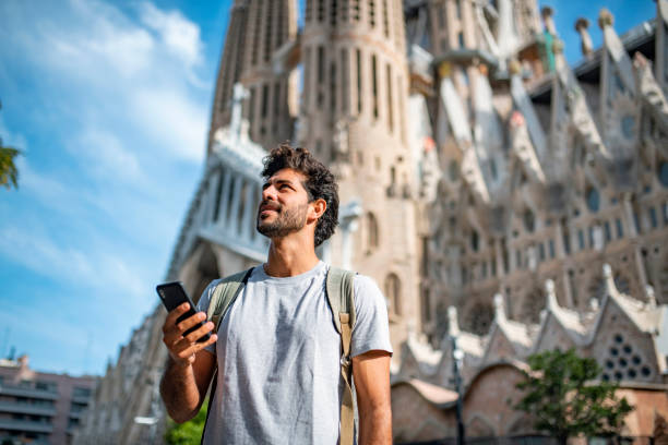 mid adult male tourist with smart phone in barcelona - travel stock pictures, royalty-free photos & images