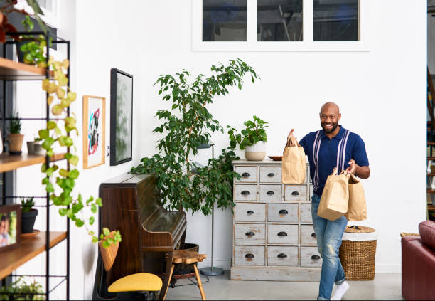 mid adult man bringing takeaway food back home - junk food stock pictures, royalty-free photos & images