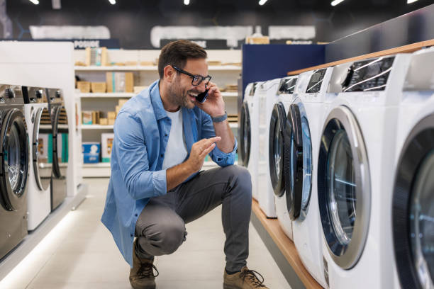mid adult man buying a washing machine in an appliance store - home decoration stock pictures, royalty-free photos & images