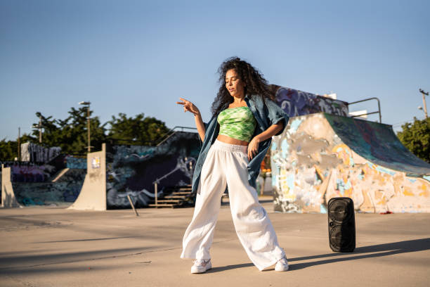 mid adult woman dancing reggaeton at skateboard park - fashion stock pictures, royalty-free photos & images