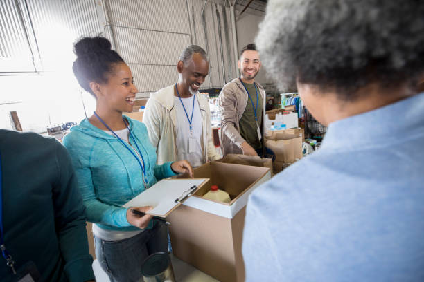 mid adult woman enjoys organizing food bank donations - food stock pictures, royalty-free photos & images