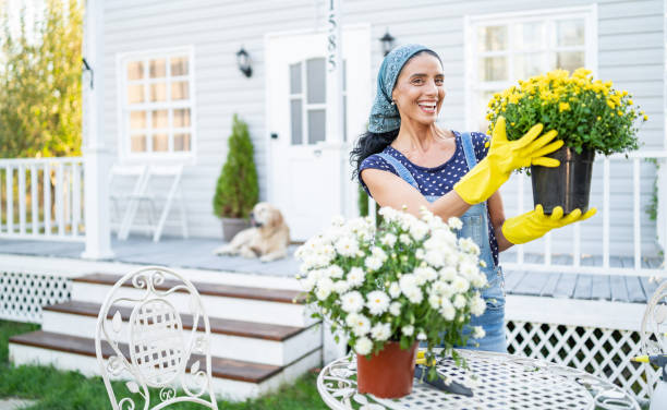 mid adult woman planting flowers in front of a porch - garden decoration stock pictures, royalty-free photos & images