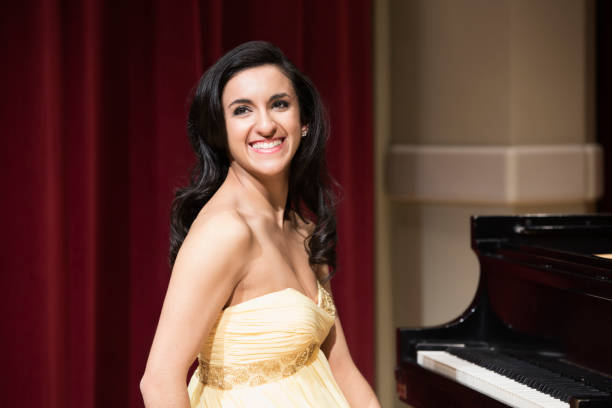 middle eastern woman smiling at piano - concert stock pictures, royalty-free photos & images