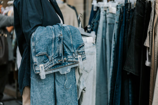 midsection of female owner holding jeans coathanger - fashion stock pictures, royalty-free photos & images
