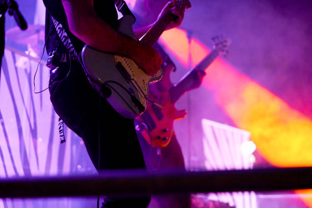 midsection of performance musician playing guitar in rock music concert - concert stock pictures, royalty-free photos & images