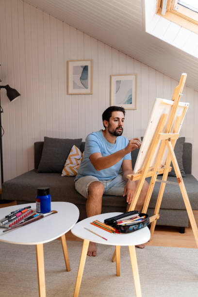 mise au point sélective d’un jeune homme dessinant une image sur un chevalet à la maison - nails art photos et images de collection