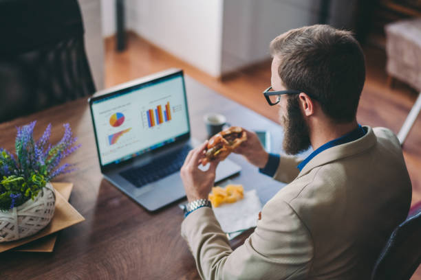 mittagessen bei der arbeit - junk food stock-fotos und bilder