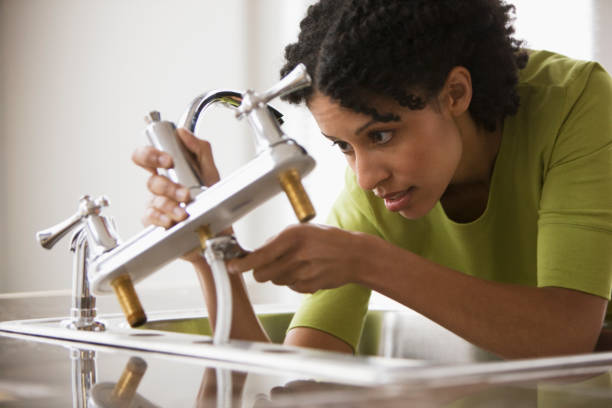 mixed race woman installing faucet - home decoration stock pictures, royalty-free photos & images