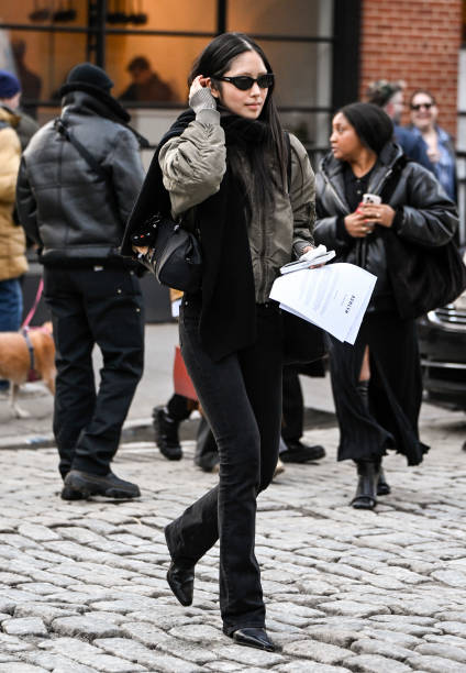 Model Houjing Cui is seen wearing a green jacket, black pants, black scarf and black sunglasses outside the Ashlyn show during NYFW F/W 2025 on...
