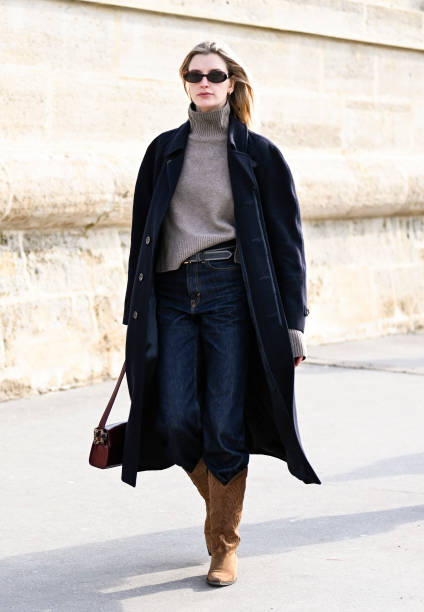 Model Ieva Palionyte is seen wearing a black coat, gray sweater, blue jeans and brown cowboy boots outside the Dior show during the Womenswear...