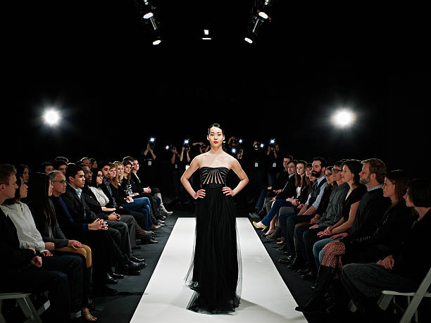 model in gown walking down catwalk - fashion stock pictures, royalty-free photos & images
