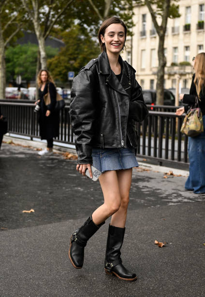 Model is seen wearing a black biker jacket, denim skirt and black boots outside the Chanel show during the Womenswear Spring/Summer 2024 as part of...