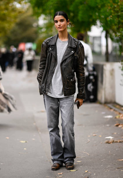 Model is seen wearing a black biker jacket, gray shirt and gray jeans outside the Zimmermann show during Womenswear Spring/Summer 2025 as part of...