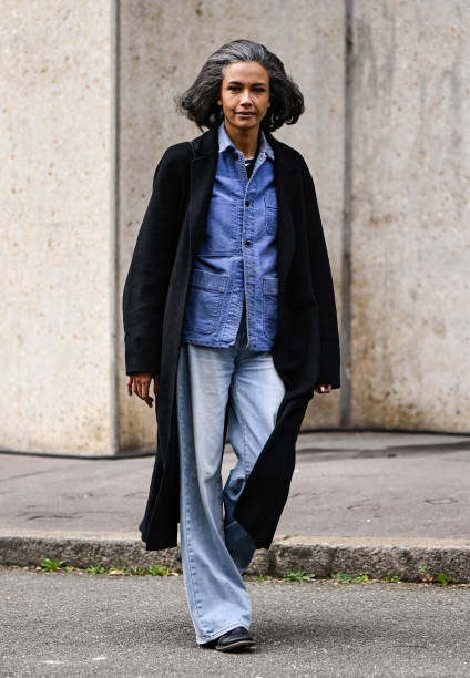 Model is seen wearing a black coat, blue shirt, faded jeans, black shoes and black bag outside the Miu Miu show during the Womenswear Fall/Winter...
