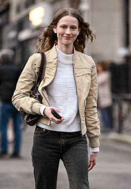 Model Melinda Kiss is seen wearing a tan jacket, white shirt, black and brown faded jeans and brown bag outside the Rokh show during the Womenswear...
