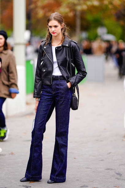 Model wears a black leather jacket, blue flared jeans pants, outside Chanel, during Paris Fashion Week Womenswear Spring/Summer 2019 on October 2,...